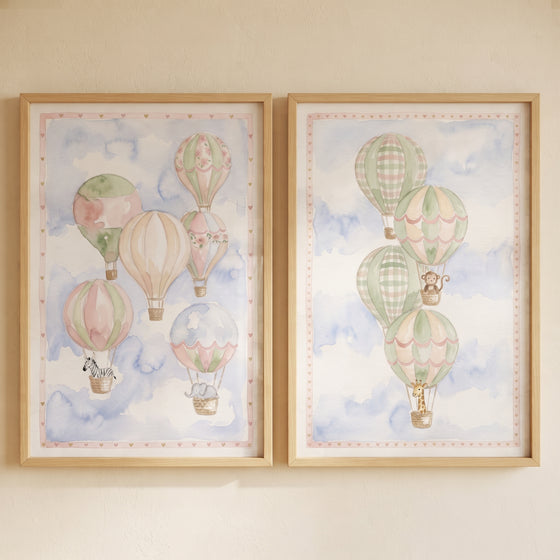 Watercolor pastel sky balloon wall art set of 2 featuring hot air balloons and animals in light wood frames.
