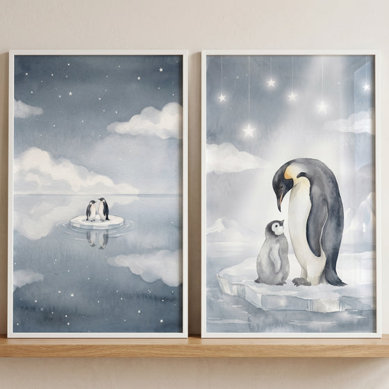 Watercolor starry blue penguin wall art set of 2 depicts penguins on ice floes under soft stars and clouds.