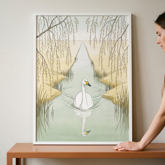 Framed weeping willow white swan wall art showing a swan in a canal, resting on a table next to a person.
