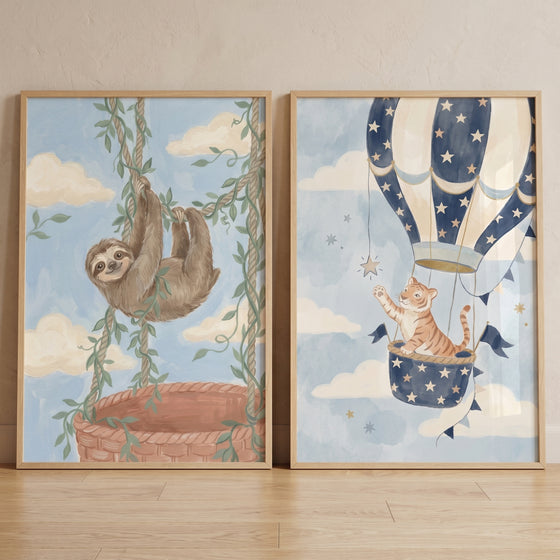 Whimsical blue sky animals wall art set of 2 featuring a sloth on vines and a tiger in a star-patterned hot air balloon.