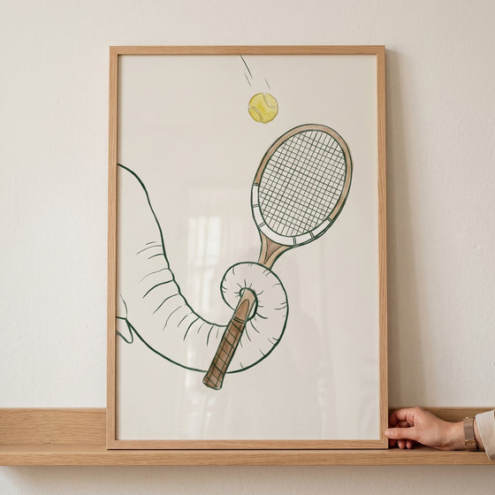 Framed yellow tennis ball elephant print featuring an elephant trunk holding a tennis racket with a ball in the air.