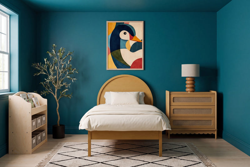 A bold kids' room: a deep saturated teal accent wall and ceiling, a honey-oak arched twin bed with a cream duvet, and a colorful geometric duck art print above the bed