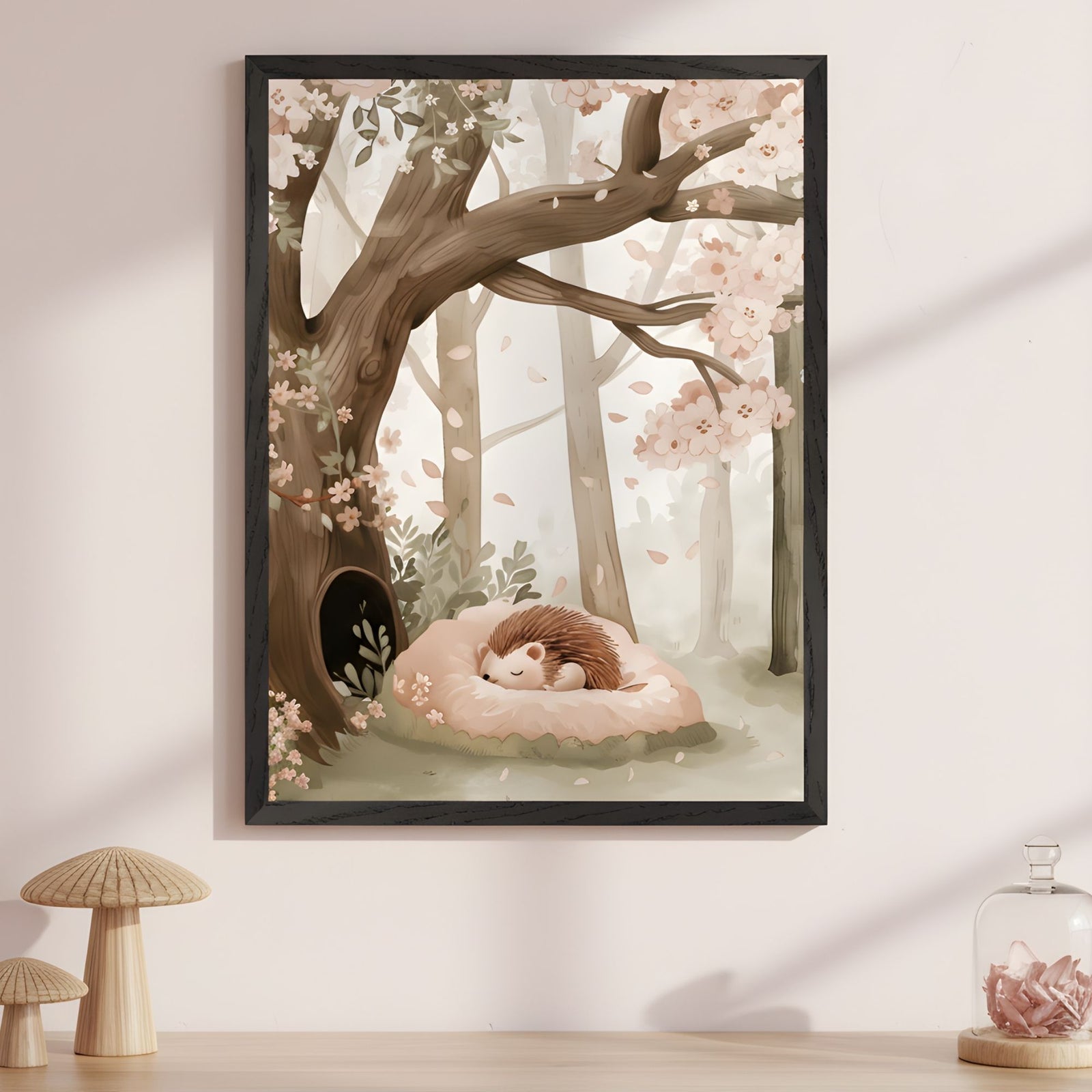 Framed illustration of a sleeping hedgehog curled up on a soft pink cushion under a large tree in a forest filled with blooming cherry blossoms. Gentle petals fall around the peaceful woodland scene, creating a calm and dreamy spring atmosphere.