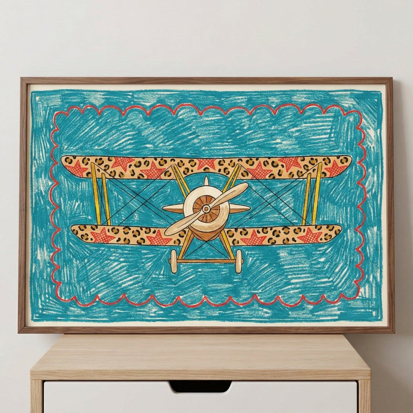 Framed biplane and aircraft wall art featuring leopard print and red stars, housed in a medium-toned wooden frame and displayed sitting on a light wood cabinet against a white wall.