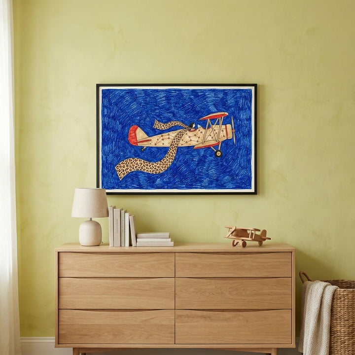 Whimsical airplane biplane wall art hanging above a light wood dresser in a Scandinavian-style nursery.