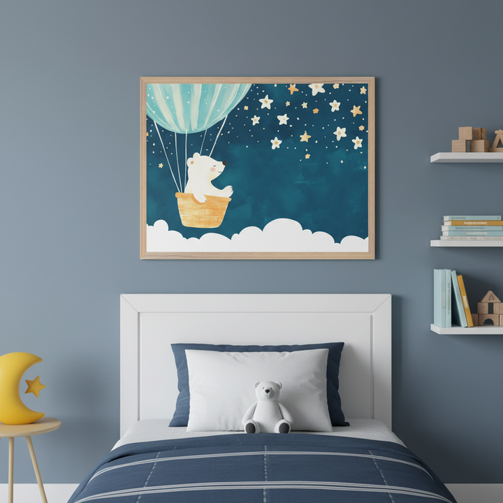 Kid's bedroom with a white bed and blue bedding. A large framed watercolor print of a white bear in a hot air balloon under a starry sky hangs above the headboard. White floating shelves with books are on the right. A yellow moon lamp is on a side table.