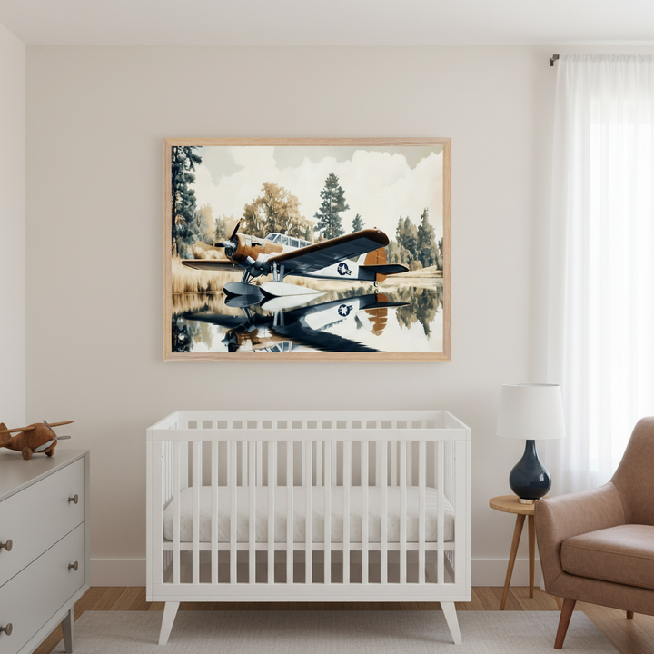Modern nursery with a white crib and gray dresser. A large framed painterly print of a sepia-toned floatplane with US markings on calm water reflecting trees hangs centered above the crib. A brown armchair and side table are to the right.