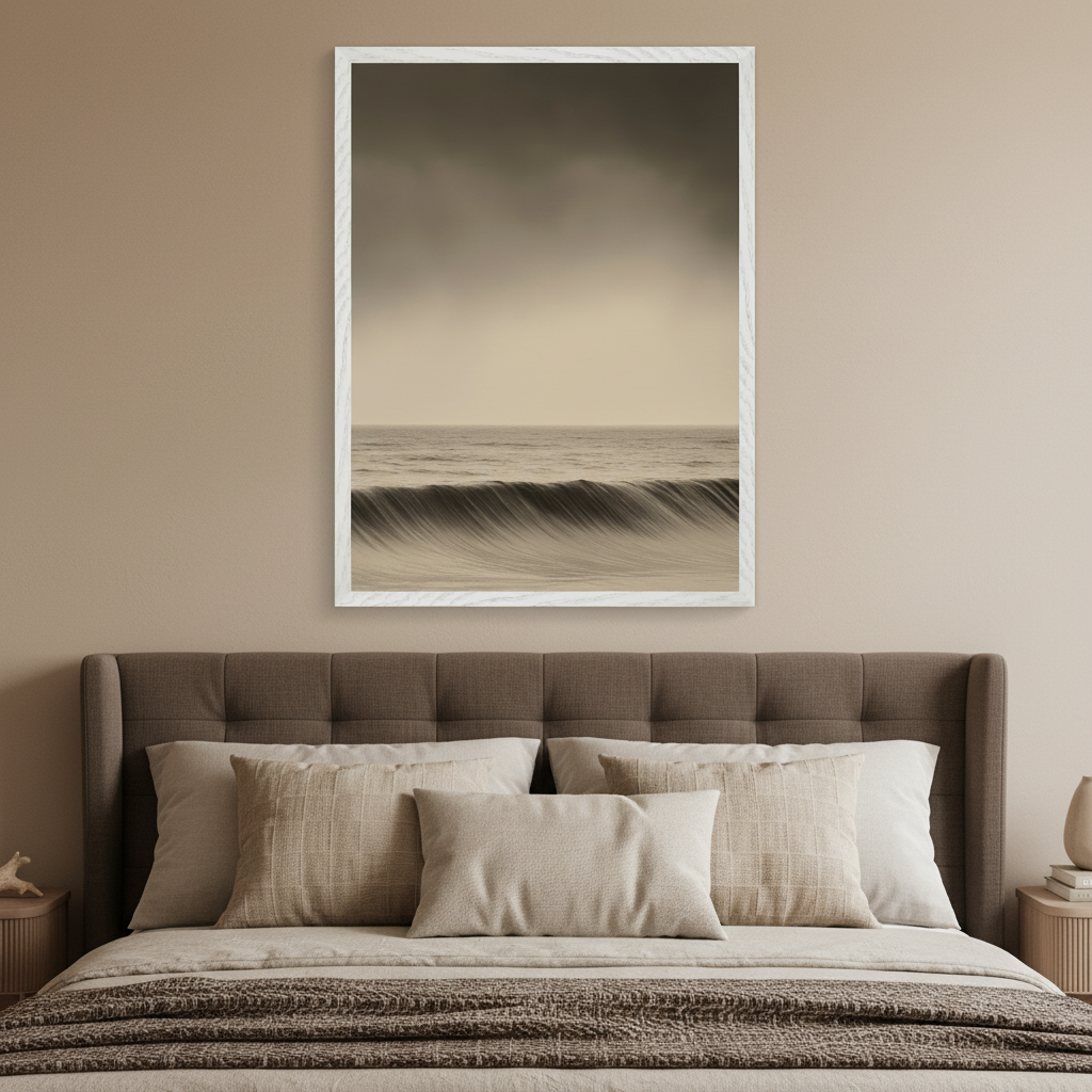 Modern neutral bedroom with a brown upholstered bed. A large framed monochromatic photo of a breaking ocean wave hangs centered above the bed.