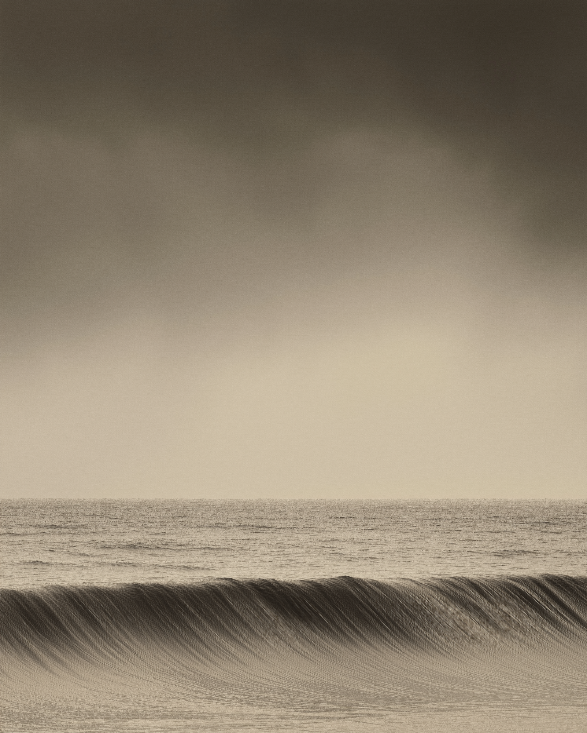 A soft sepia-toned seascape showing a gentle wave curling under a moody sky. The scene feels calm and meditative, blending natural beauty with a sense of quiet depth.
