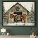 Modern room with a dark green wall. A large framed watercolor painting of a brown horse with a plaid blanket in front of a snow-covered barn and Christmas trees hangs above a light beige console table. A white lamp and a vase with branches are on the table.