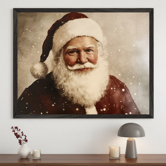 Modern room with a dark wood credenza. A large framed painting of Santa Claus, smiling with a white beard and red hat against a snowy background, hangs centered above the credenza. A vase with berries, two lit candles, and a gray lamp are on the credenza.