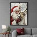Modern living room with a gray sofa. A large framed painting of Santa Claus hugging a reindeer with a snowy background hangs above the sofa. A wooden side table with a lamp and small Christmas tree is to the left.
