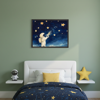 Kid's bedroom with a white bed and blue star-patterned comforter. A framed painting of an astronaut collecting stars from a dark blue sky hangs centered above the bed. White floating shelves hold an astronaut figure and a yellow star pillow.