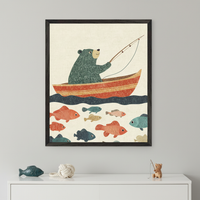 Kid's room with a white dresser. A framed illustration of a green bear fishing from a red boat, surrounded by many colorful fish, hangs centered above the dresser. A blue fish figurine, decorative knot, and tiny wooden bear fishing figurine are on the dresser.