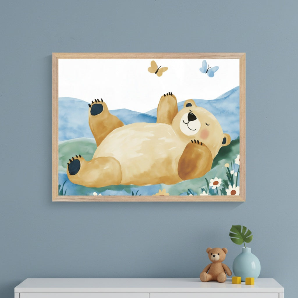 Modern nursery with a blue-gray wall and a white dresser. A large framed watercolor print of a bear lying on its back in a grassy field with blue hills and butterflies hangs above the dresser.