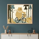 Modern room with a teal wall and a light wood and white dresser. A large framed whimsical illustration of a brown bear riding a bicycle with a cub in the basket in a forest hangs above the dresser.
