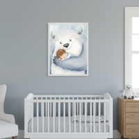 Modern nursery with a gray wall. A framed print of a smiling white yeti holding a sleeping child hangs centered above a white crib. A white armchair is on the left, and a wooden dresser with a white teddy bear is on the right.