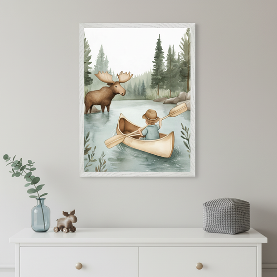Modern child's room with a white dresser. A framed watercolor painting depicting a child in a canoe on a lake interacting with a moose hangs centered above the dresser. Decor includes a vase, wooden moose toy, and gray knitted pouf.