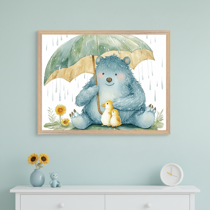 Nursery with a light blue wall and white dresser. A framed watercolor of a blue bear holding a green umbrella over two yellow ducklings, with rain and sunflowers, hangs centered above the dresser. A vase with sunflowers, a toy bear, and a white clock are on the dresser.