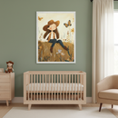 Modern nursery with a light wood crib and dresser against a green wall. A large framed illustration of a smiling girl in a hat on a hay bale with butterflies hangs above the crib.