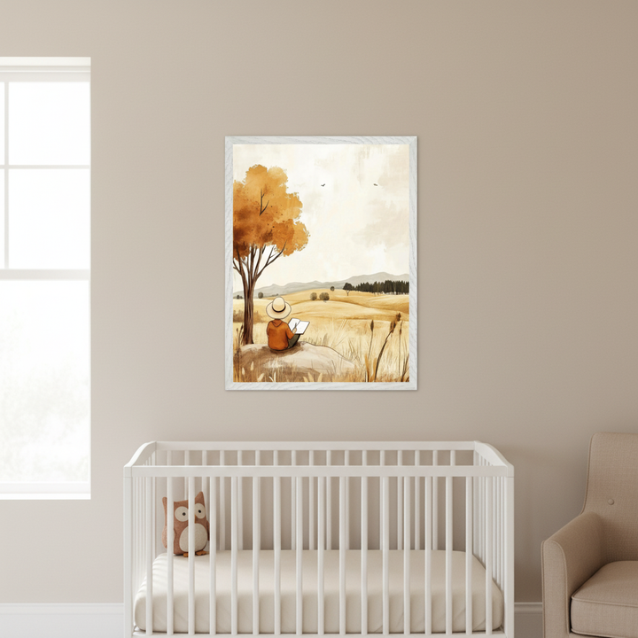 Modern nursery with a white crib and cream armchair. A framed watercolor-style print hangs on the wall above the right side of the crib. It depicts a person in a hat reading under an autumn tree in a golden field.