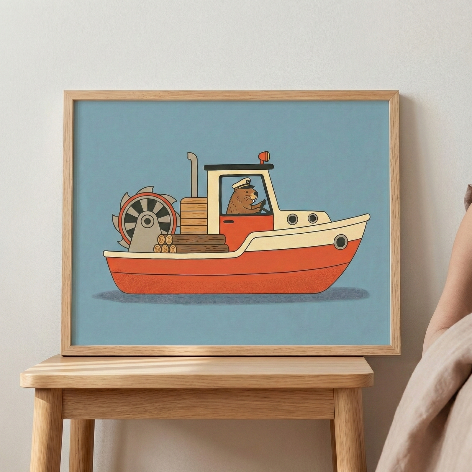 Framed wall art of a beaver captain on a boat, presented in a light wood frame resting on a matching wooden stool beside a bed.