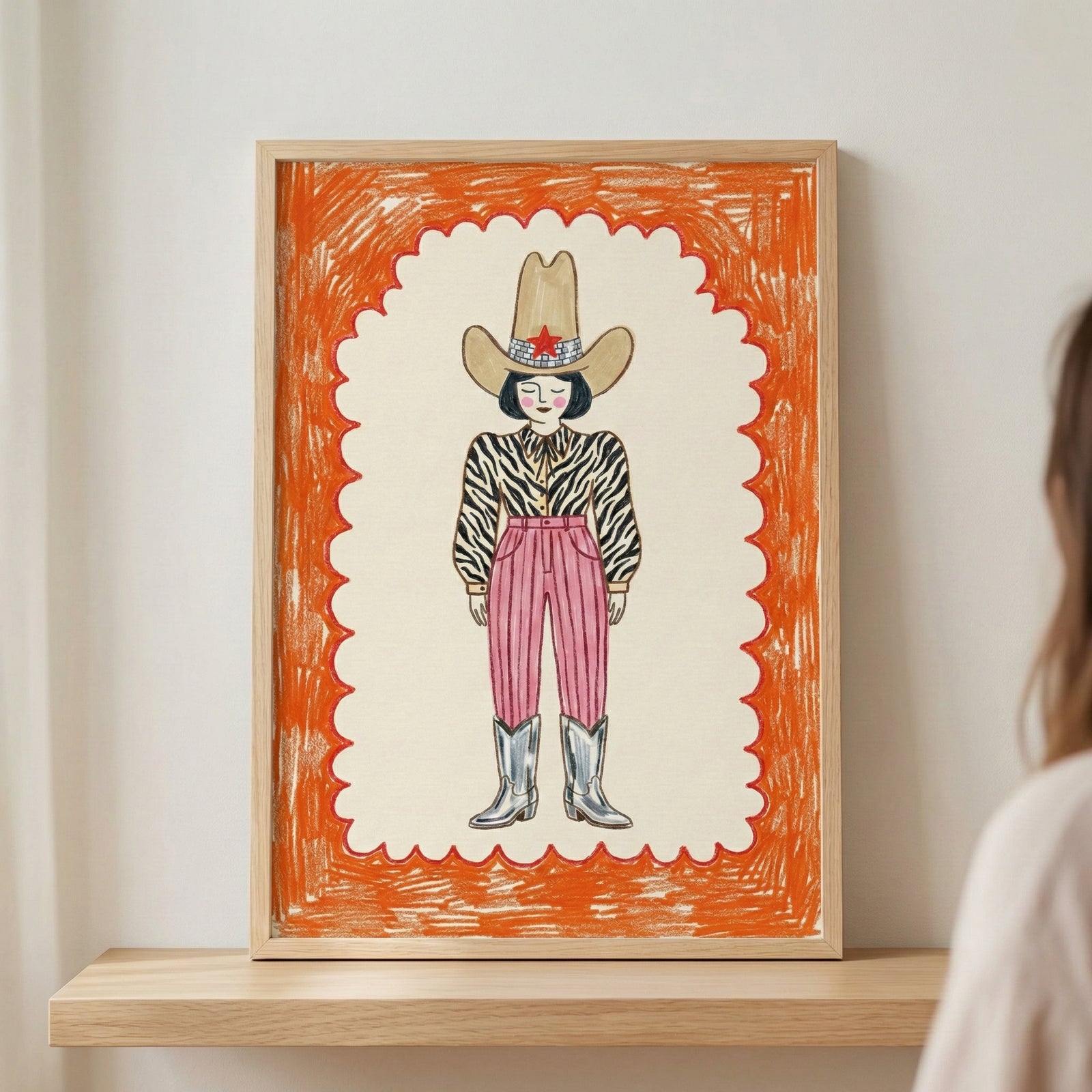 Framed crayon-style drawing of a fashionable cowboy figure with a zebra-striped shirt, high-waisted pink pants, silver boots, and a large tan hat with a red star. The bold orange scalloped border adds a playful, energetic touch to the portrait.