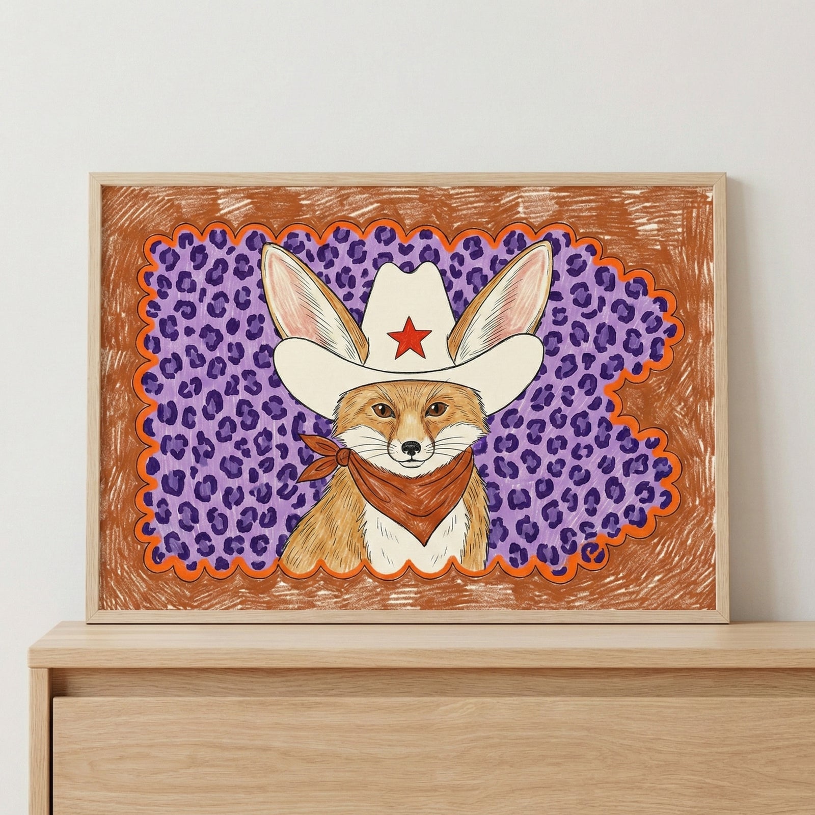 Framed wall art of a fennec fox wearing a large white cowboy hat with a red star and a brown bandana, set against a bold purple leopard print and orange crayon-textured background. This vibrant animal portrait adds a playful pop to kids’ wall art or eclectic decor.