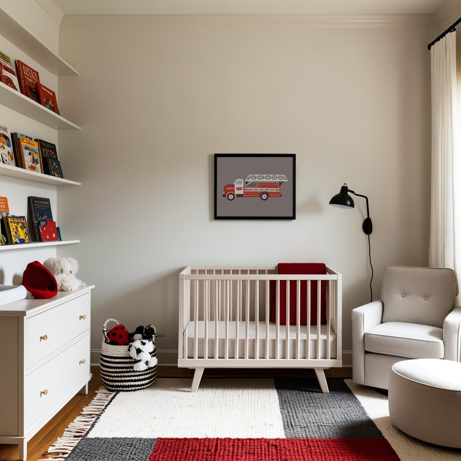 A sleek nursery with cream walls and modern decor, featuring a minimalist crib with a red blanket and a framed fire truck illustration above. The room includes a white dresser, wall-mounted shelves filled with colorful books, and a basket of plush toys. A neutral armchair, black reading lamp, and a geometric-patterned rug with red, white, and gray accents complete the stylish design.