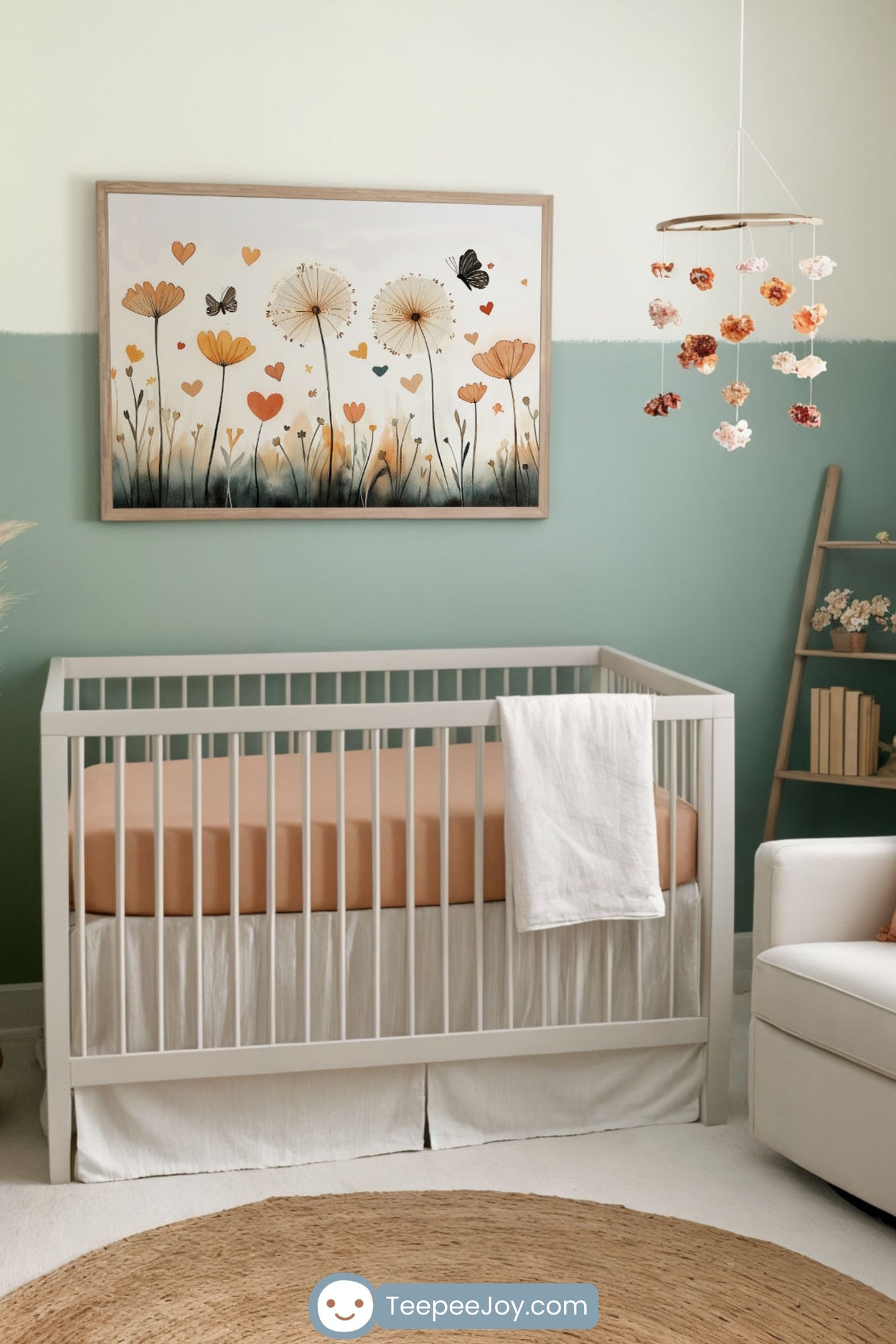 Serene and nature-inspired nursery featuring a white crib with a soft peach mattress against a two-toned sage and cream wall. Above the crib hangs a framed watercolor painting of dandelions, wildflowers, and butterflies with floating heart-shaped petals. A cozy white armchair with a peach pillow and knit throw, a woven jute rug, wooden furniture, and delicate floral decor create a warm and calming space.