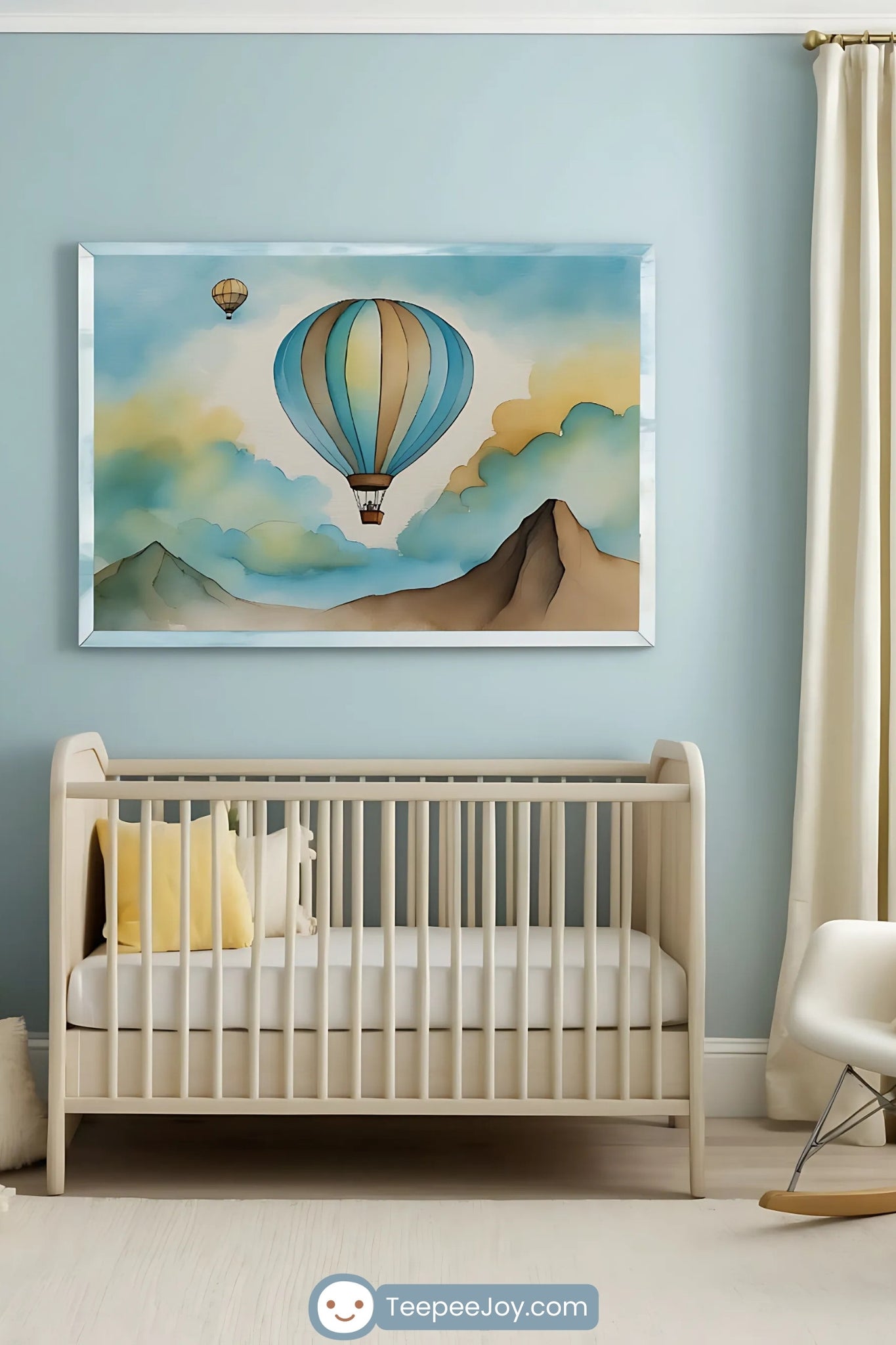This image portrays a serene and elegant nursery with a soft blue color palette and light wood furniture. A watercolor-style hot air balloon artwork hangs above the crib, featuring muted blues and browns that complement the room's airy atmosphere. Yellow and cream accents in the form of pillows, a cozy chair, and soft textiles add warmth and brightness, creating a tranquil yet cheerful environment for a baby.