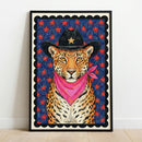 A whimsical, child-like illustration of a leopard wearing a black cowboy hat with a gold star and a bright pink bandana, centered within a black scalloped border on a textured blue background filled with red stars.
