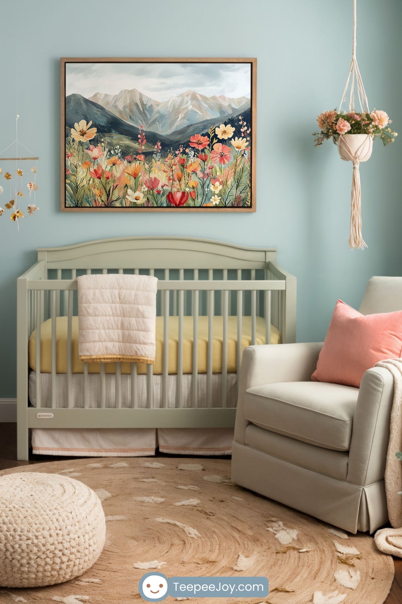 Soft and serene nursery with pastel blue and pink walls, featuring a sage green crib and a framed mountain and wildflower painting above. A wooden dresser with a changing pad sits to the left, while a cream armchair with a pink pillow and cozy throw is near a window with floral curtains. A woven pouf, hanging macramé planter, and floral mobile complete the warm, nature-inspired design.