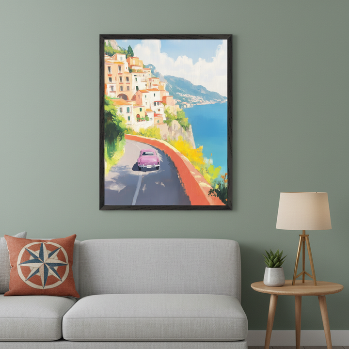 Sage green living room with a light gray sectional sofa and wood side table. A large framed painting above the sofa shows a pink car on a coastal road with cliffside houses and a blue sea, in an impressionistic style.
