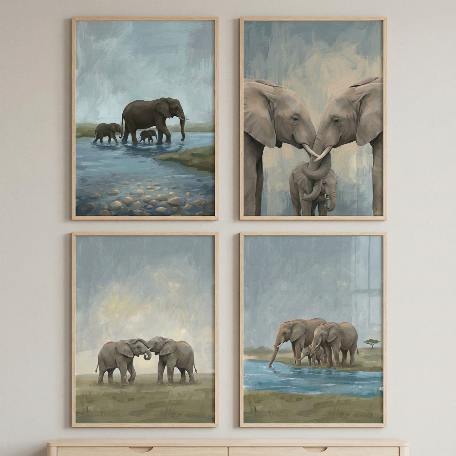 Four framed elephant paintings arranged in a grid show calm wildlife scenes in soft muted tones. The artworks include a mother elephant walking through shallow water with two calves, two adult elephants touching trunks above a baby, two young elephants gently meeting trunks, and a small herd standing together beside a watering hole. The coordinated safari artwork creates a peaceful nature inspired wall display.