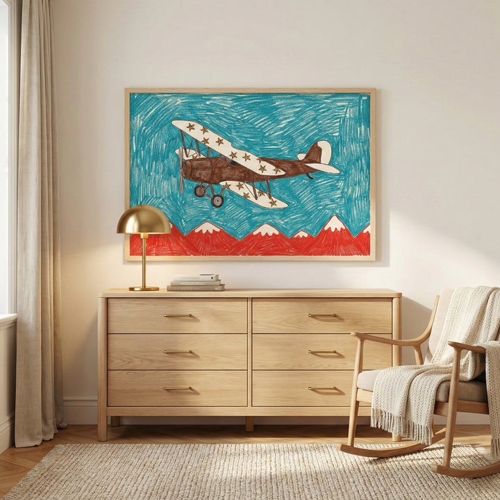 Framed drawing of a vintage airplane flying over red mountains displayed above a light wood dresser in a cozy, sunlit room. The playful art adds a touch of adventure and color to the minimalist interior.