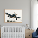 Modern nursery with a white crib and wooden dresser. A large framed print of a blue vintage propeller plane flying over pine trees and misty mountains hangs centered above the crib.