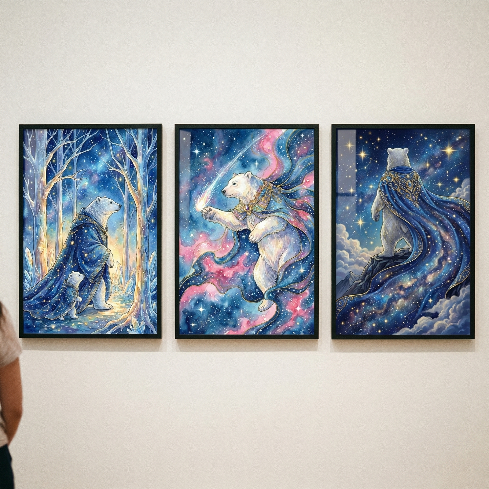 Three vertical framed illustrations hang side-by-side on a plain, off-white wall. Each piece features a polar bear in a celestial, fantasy-themed setting. 
The frame on the left shows a large polar bear accompanied by a smaller cub. Both wear flowing, dark blue cloaks decorated with golden stars. They are walking through a grove of slender, glowing white trees under a brilliant, starry night sky.
