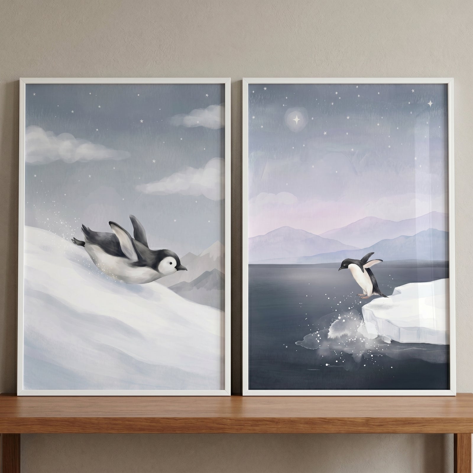 Arctic starry night penguin wall art set of 2 shows a penguin sliding down snow and another jumping into water from ice.