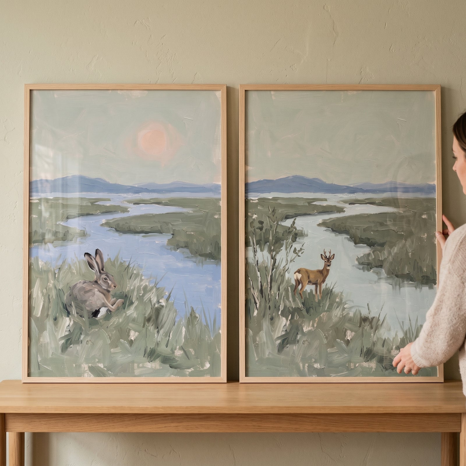 Atmospheric sage marsh wildlife animals wall art set of 2 featuring a hare and a deer in a landscape on a wood table.