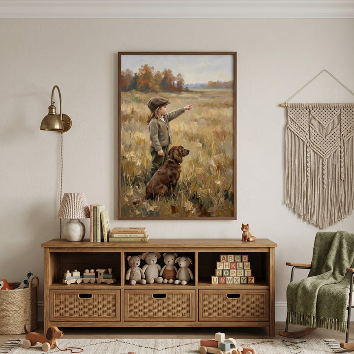 Autumnal pointing brown dog wall art hangs above a wooden sideboard with toys, books, and a macrame wall hanging.