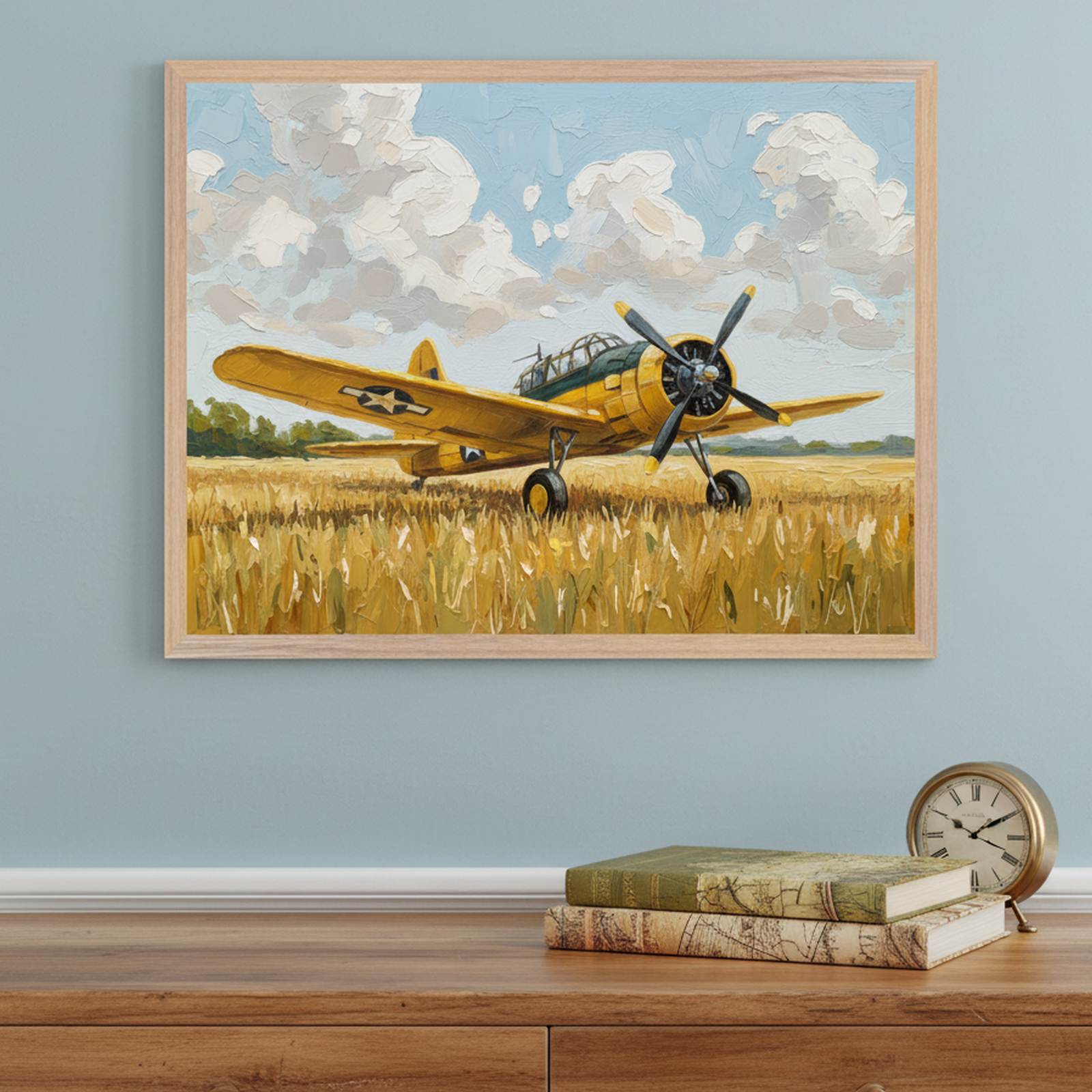 This art shows a vintage yellow military aircraft with a U.S. Air Force insignia parked in a golden wheat field under a sky filled with fluffy clouds. The bold brushstrokes and warm tones evoke a nostalgic, rural setting, with the artwork placed above a wooden dresser decorated with antique-style books and a classic round clock.