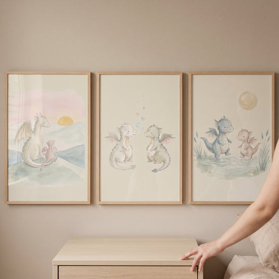 Baby dragon wall art set of 3 in light wood frames features cute watercolor dragons in soft pastel colors.