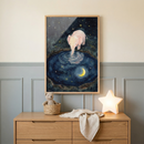 A framed rectangular artwork hangs on a wall above a light wood dresser. The artwork depicts a small, light pink cartoon elephant standing by a circular pool of water at night. The elephant's trunk is dipped into the water, which reflects a yellow crescent moon and numerous tiny stars, mirroring the starry night sky above. Below the frame, a wooden dresser sits against a wall with light blue-grey paneling. 