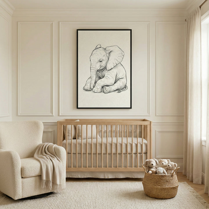 A minimalist, neutrally-toned nursery featuring a light wood crib centered under a large framed black-and-white sketch of a baby elephant. To the left sits a textured cream armchair with a matching throw blanket, and to the right, a woven basket is filled with stuffed animals. The room is bright and serene, with decorative wall molding and a large window draped in soft cream curtains.