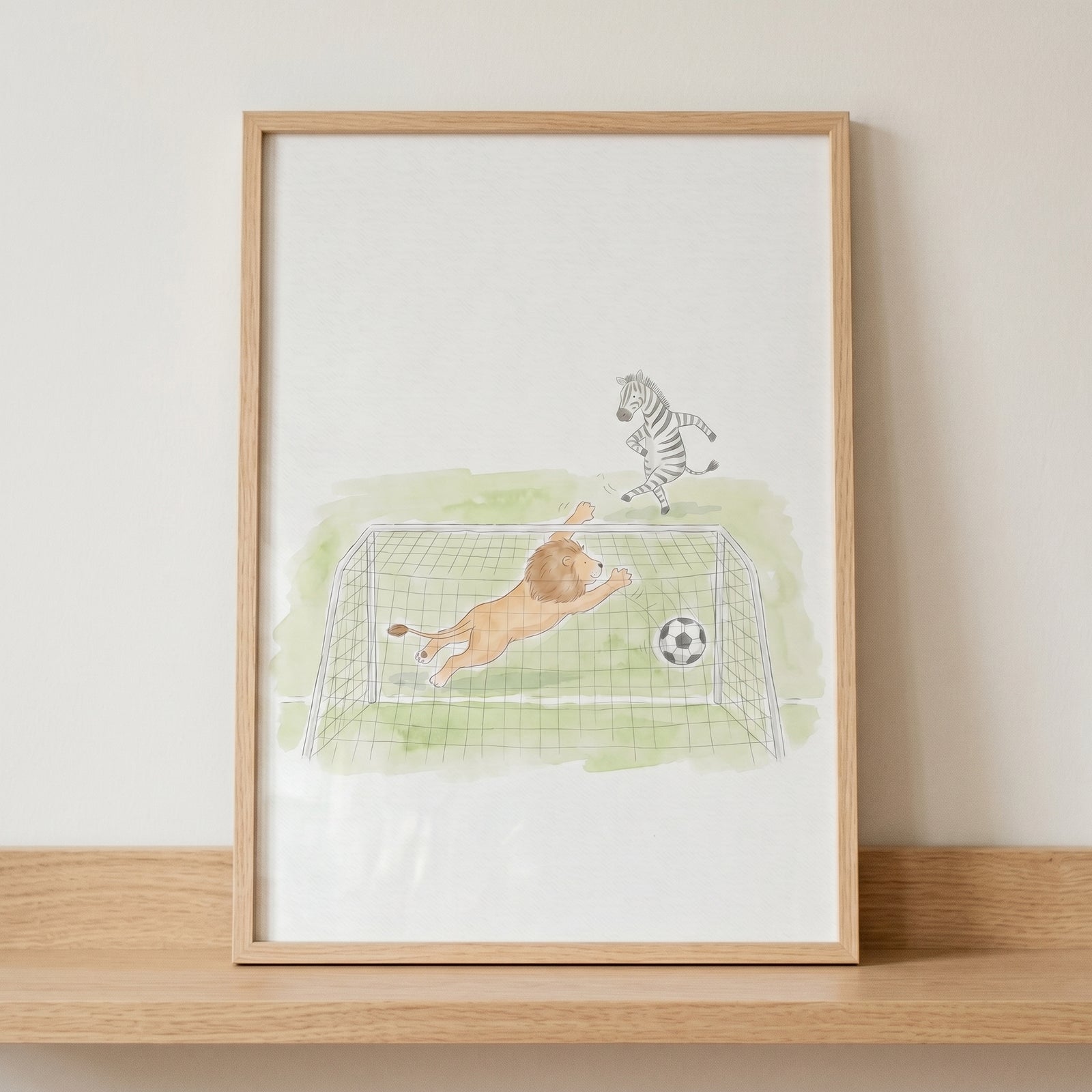 Framed watercolor illustration of a lion goalie diving for a soccer ball and a zebra on a grassy field.