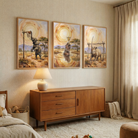 Three framed safari animal paintings hang above a wooden dresser in a cozy bedroom. The artwork shows an elephant reaching up to a rustic basketball hoop, a hippo standing in water holding a gold trophy, and a rhinoceros guarding a handmade soccer goal beneath a swirling golden sun.