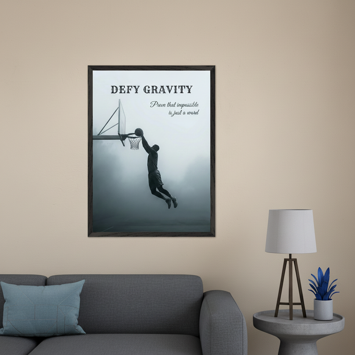 Modern living room with a grey sofa. A large framed black and white print of a basketball player dunking, with text 'DEFY GRAVITY / Prove that impossible is just a word', hangs centered above the sofa.