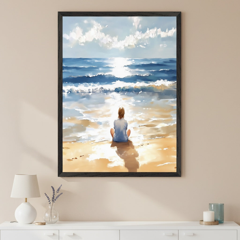 Modern room with a white dresser. A large black-framed painting of a person sitting on a sunny beach looking at the ocean hangs centered above the dresser. The art shows bright sunlight reflecting on the water and sand in a painterly style.