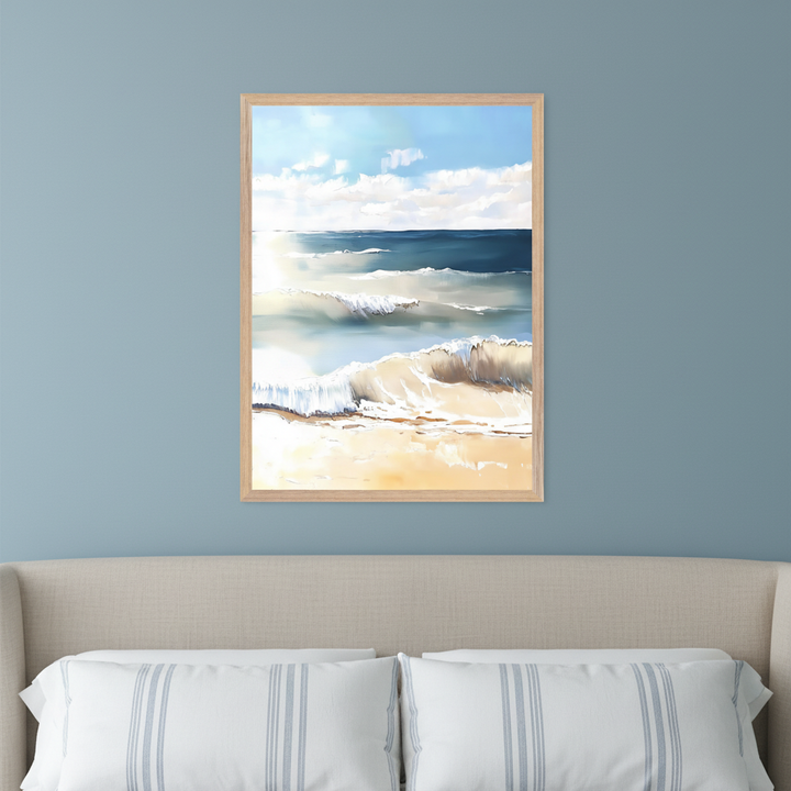 Bedroom with a beige upholstered bed and striped pillows. A framed painting of an ocean beach scene with breaking waves, a sandy shore, and a sunny blue sky hangs centered above the bed.